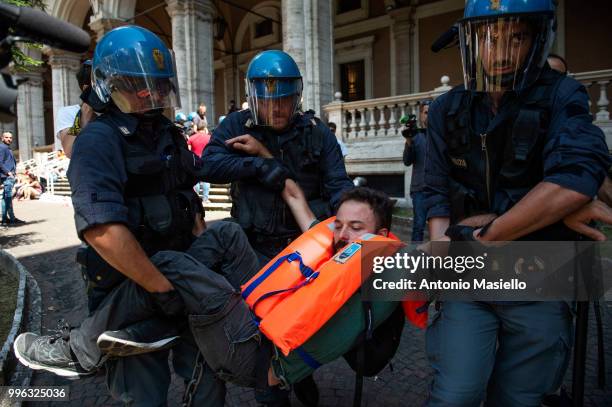 Italian Police remove the protesters wearing life jackets from the Ministry of Transport during a protest against the Italian immigration policy, on...