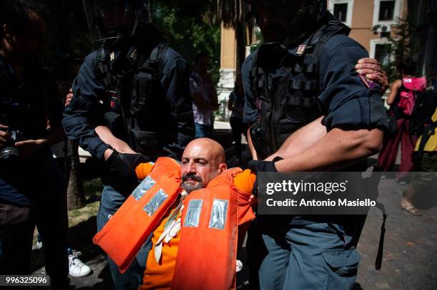 Italian Police remove the protesters wearing life jackets from the Ministry of Transport during a protest against the Italian immigration policy, on...