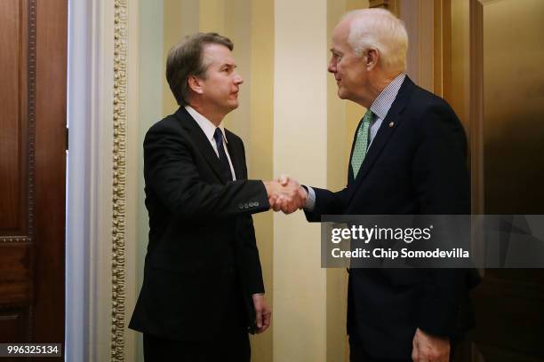 Judge Brett Kavanaugh shakes hands with Senate Majority Whip John Cornyn after a meeting in his office at the U.S. Capitol July 11, 2018 in...