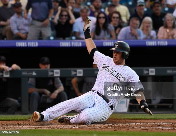 Colorado Rockies second baseman DJ LeMahieu slides safely into home thanks to Colorado Rockies center fielder Charlie Blackmon's RBI double in the...