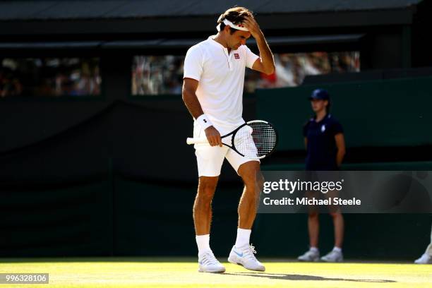 Roger Federer of Switzerland wipes his forehead against Kevin Anderson of South Africa during their Men's Singles Quarter-Finals match on day nine of...