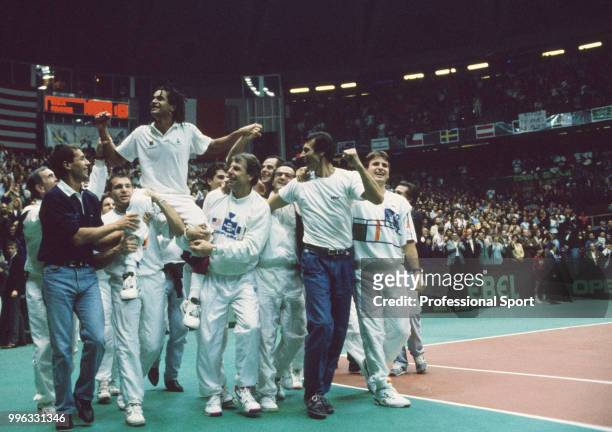 The French Davis Cup team captain Yannick Noah is lifted by his team after they defeat the USA in the Final of the Davis Cup at the Palais des Sports...