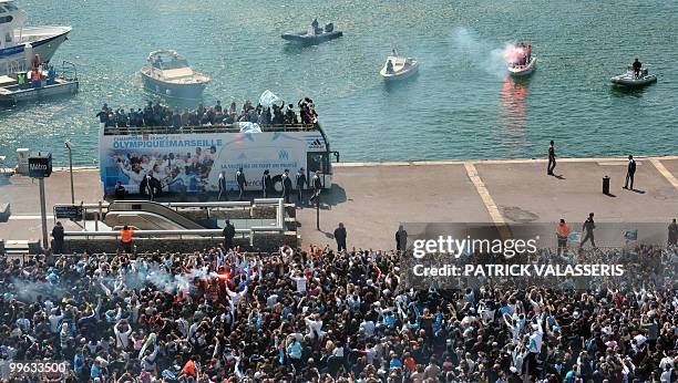 Olympique de Marseille supporters celebrate as the players parade following the team's victory in the French L1 football championship on May 16, 2010...