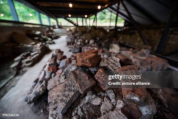 July 2018, Germany, Moerfelden-Walldorf: Wall fragments which are inscribed with names of former imprisoned Hungarian female Jews lie on the...