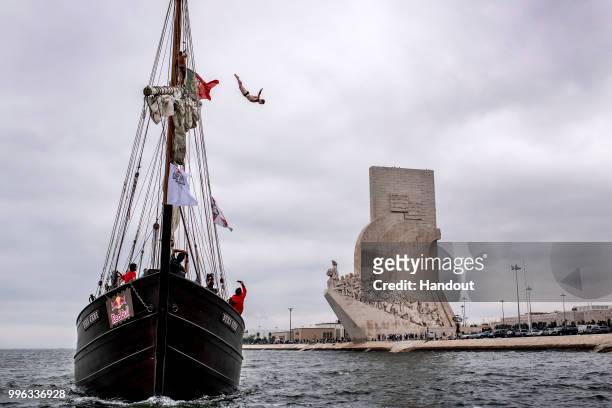 In this handout image provided by Red Bull, Andy Jones of the USA dives from the mast of the caravel Vera Cruz next to the Padrao dos Descobrimentos...