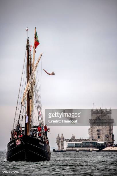 In this handout image provided by Red Bull, Andy Jones of the USA dives from the mast of the caravel Vera Cruz next to the Belem Tower prior to the...