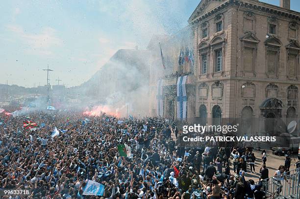 Olympique de Marseille supporters celebrate Marseille's players as they appear on the town hall balcony following the team's victory in the French L1...