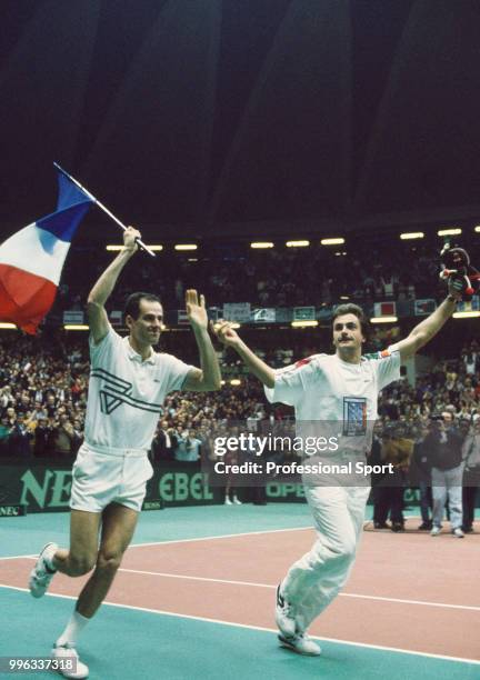 Guy Forget and Henri Leconte of France celebrate with their country's flag after defeating the USA in the Final of the Davis Cup at the Palais des...