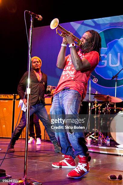 Musician Lenny Kravitz looks on as New Orleans jazz trumpeter Shamarr Allen performs at the GULF AID benefit concert at Mardi Gras World River City...