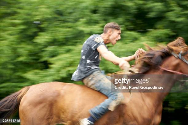 young roma men (gypsies) participating in a horse competition during the traditional national festivity in the neighborhood of baba kondu in the municipality of targovishte, bulgaria - jockey isolated stock pictures, royalty-free photos & images