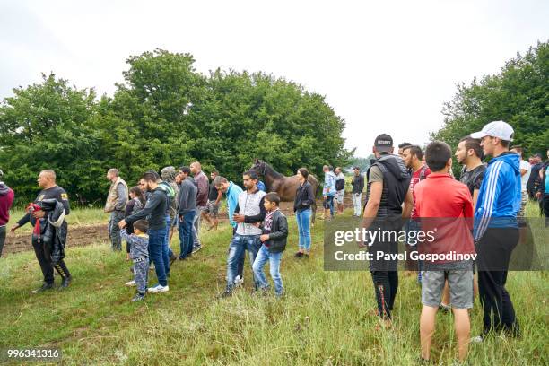 christian and muslim romanies (gypsies), ethnic turks and bulgarians enjoying a traditional horse competition during the traditional national festivity in the neighborhood of baba kondu in the municipality of targovishte, bulgaria - pavel gospodinov stock pictures, royalty-free photos & images