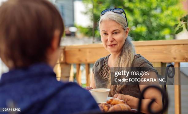 patio time with moter and son - shade45 stock pictures, royalty-free photos & images