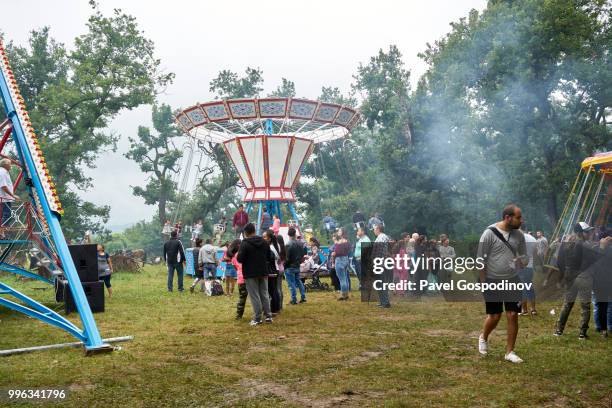 christian and muslim romanies (gypsies), ethnic turks and bulgarians entertaining at a primitive amusement park during the traditional national festivity in the neighborhood of baba kondu in the municipality of targovishte, bulgaria - pavel gospodinov stockfoto's en -beelden