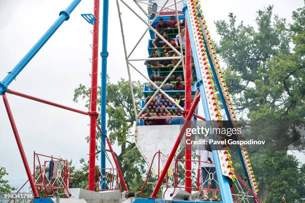 christian and muslim romanies (gypsies), ethnic turks and bulgarians entertaining at a primitive amusement park during the traditional national festivity in the neighborhood of baba kondu in the municipality of targovishte, bulgaria - baba stockfoto's en -beelden