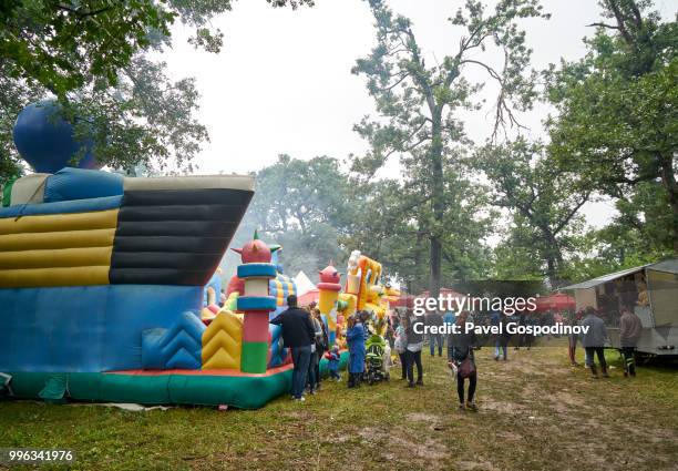 christian and muslim romanies (gypsies), ethnic turks and bulgarians entertaining at a primitive amusement park during the traditional national festivity in the neighborhood of baba kondu in the municipality of targovishte, bulgaria - carousel musical fotografías e imágenes de stock