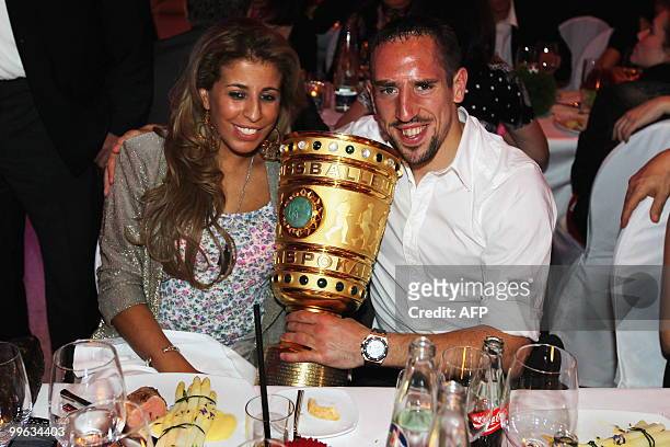 Bayern Munich's French midfielder Franck Ribery and his wife Wahiba pose with the trophy during the celebration party after the DFB German Cup final...