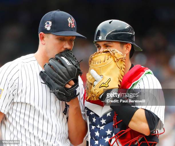 Pitcher Chad Green speaks with catcher Kyle Higashioka of the New York Yankees on the mound during the 7th inning in an interleague MLB baseball game...