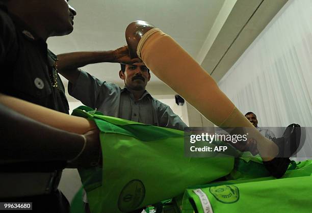 Sri Lankan soldier lifts an artificial limb to be distributed among disabled soldiers during an event at the army headquarters in Colombo on May 17,...