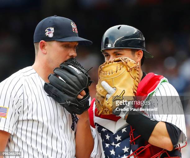 Pitcher Chad Green speaks with catcher Kyle Higashioka of the New York Yankees on the mound during the 7th inning in an interleague MLB baseball game...