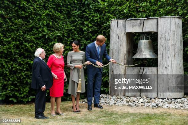 Britain's Prince Harry and wife Meghan, Duke and Duchess of Sussex hold the cord of the Peace Bell in the gardens of the Presidential mansion...