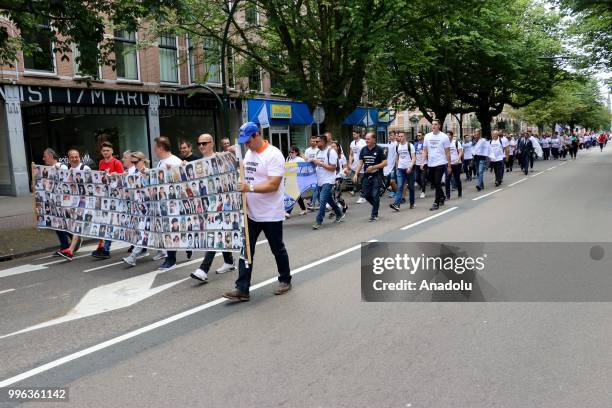 Hundreds of people gather to attend the commemoration ceremony to mark the 23rd anniversary of the 1995 Srebrenica massacre as they pass by...