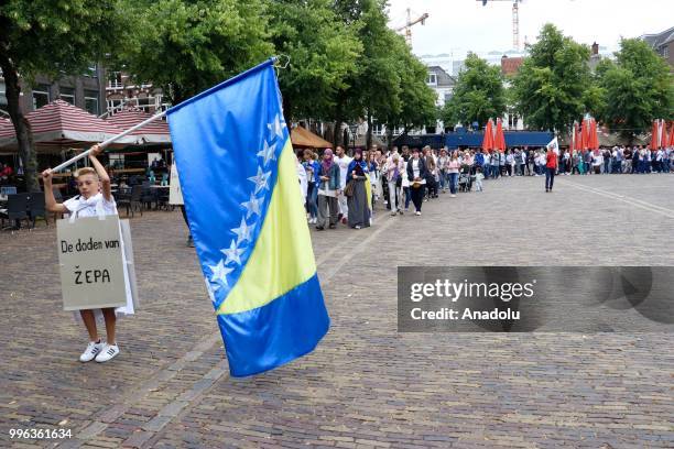 Hundreds of people gather to attend the commemoration ceremony to mark the 23rd anniversary of the 1995 Srebrenica massacre as they pass by...