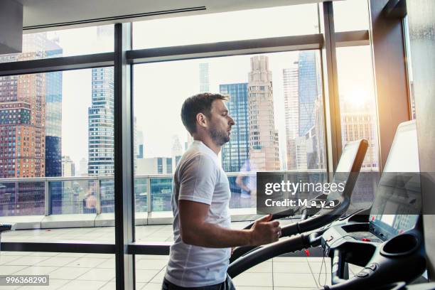 mannelijke atleet draait op loopband - oefenapparatuur stockfoto's en -beelden