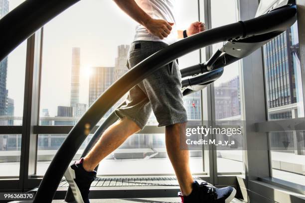 atleta masculino corriendo en caminadora - equipo de formación fotografías e imágenes de stock