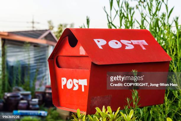 a cute red mailbox in front of the rural house - jong won heo stock pictures, royalty-free photos & images