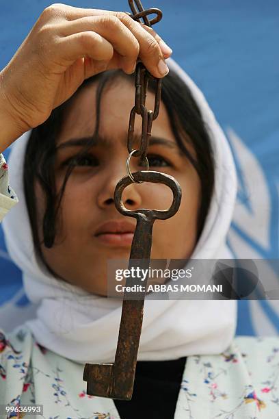 Palestinian girl holds-up a key as she attends a "Nakba" rally on May 17, 2010 in the West Bank village of Jalama close to the northern city of...