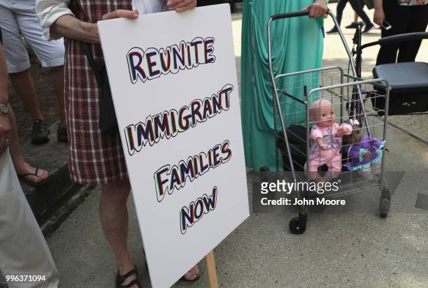 Dolls stand in a shopping cart as protesters rally against the separation of immigrant families in front of a U.S. Federal court on July 11, 2018 in...