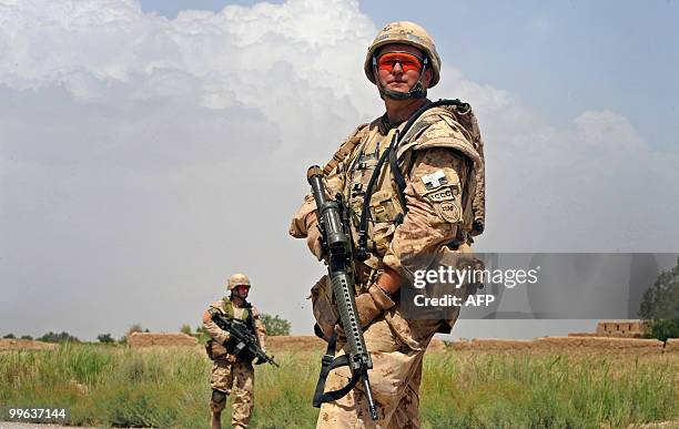 Canadian soldier Cpl Eric Thesen patrols with US soldiers from Bravo Troop 1-71 CAV in Belanday village, Dand district in Kandahar on May 17, 2010....