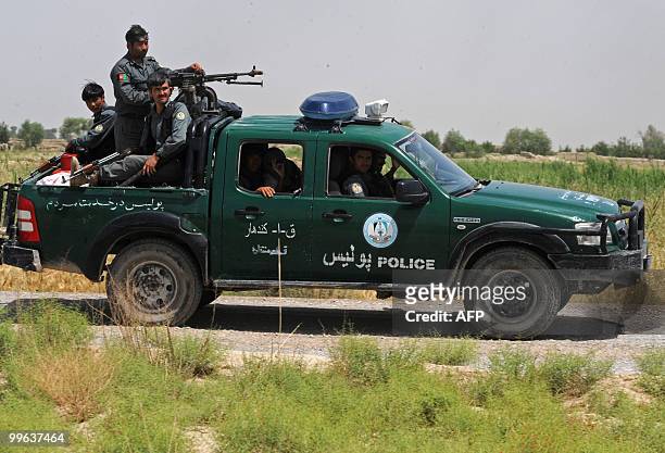 Afghan National Police ride on a pickup truck during a patrol in Belanday village, Dand district in Kandahar on May 17, 2010. NATO and the United...