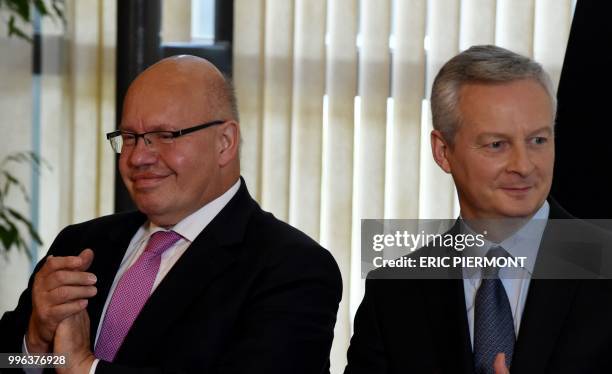 German Economy and Energy Minister Peter Altmaier and French Economy and Finance Minister Bruno Le Maire gesture as they attend a signing event prior...