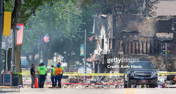 Wisconsin State Fire Marshall investigators stand on Main Street in Sun Prairie, Wisconsin on July 11, 2018 after a gas leak explosion destroyed at...