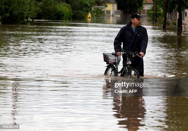 Local man pushes his bicycle in the flooded Vadasz stream in Szikszo in north-east Hungary, about 200 kms from Budapest on May 17, 2010 as heavy...