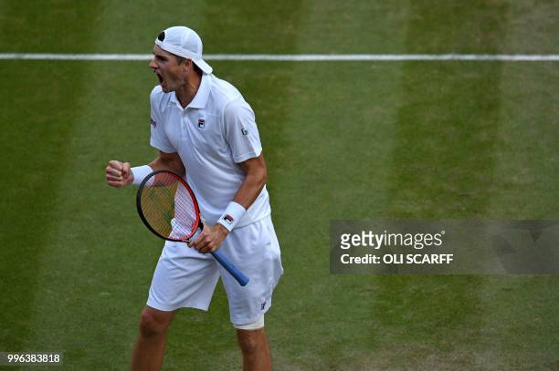 Player John Isner celebrates winning the second set against against Canada's Milos Raonic during their men's singles quarter-finals match on the...