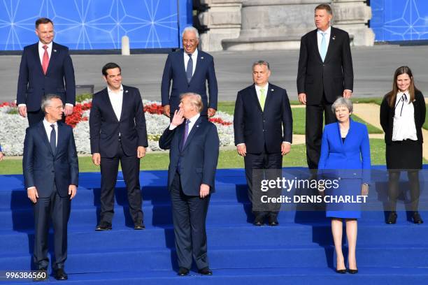 President Donald Trump shares a light moment as he waits with other leaders before a group photograph ahead of a working dinner at The Parc du...