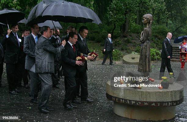 Russian President Dmitry Medvedev and President of Ukraine Viktor Yanukovych place flowers at the monument to the millions of victims of the...