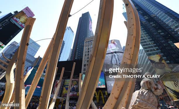 The work of artist Mel Chin, "Wake" and "Unmoored, is unveiled on Times Square July 11, 2018 in New York, part of the mixed reality piece developed...