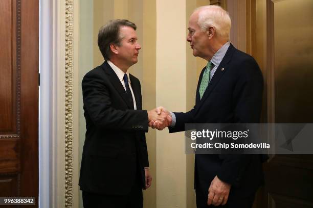 Judge Brett Kavanaugh shakes hands with Senate Majority Whip John Cornyn after a meeting in his office at the U.S. Capitol July 11, 2018 in...