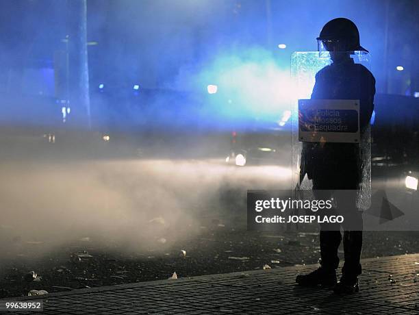 Riot policeman stands guard after disturbs during the celebration of Barcelona's supporters for the victory in their Spanish League football match...