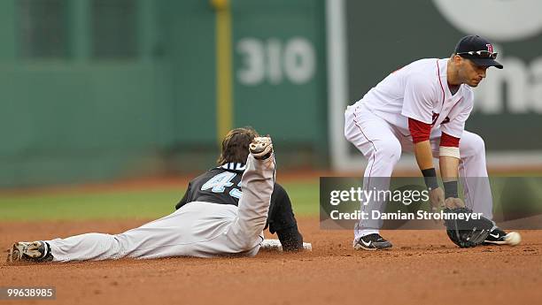 Travis Snider of the Toronto Blue Jays slides safely into second with a double as Marco Scutaro of the Boston Red Sox covers the throw during the...