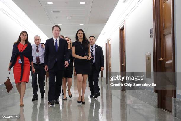 Judge Brett Kavanaugh walks down the hall in the Dirksen Senate Office Building before a meeting with Sen. Michael Crapo on Capitol Hill July 11,...