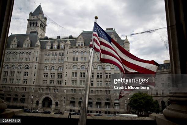 The Trump International Hotel stands past an American flag flying outside the Environmental Protection Agency headquarters in Washington, D.C., U.S.,...