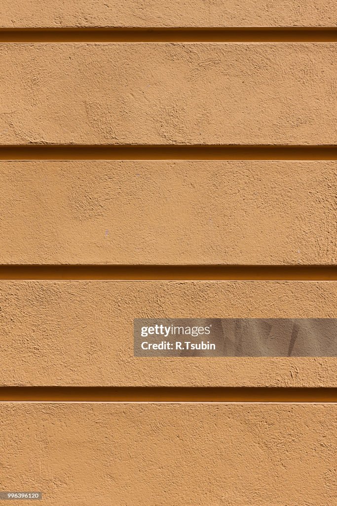 Yellow painted plaster concrete wall background. Dark edged