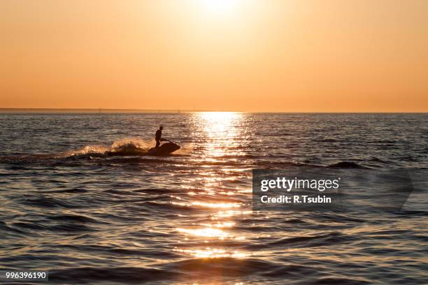 young guy cruising in the baltic sea  on a jet ski during sunset - jet ski ストックフォトと画像