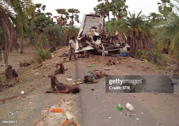 Bodies are seen near the mangled wreckage of a bus which hit a landmine in Dantewada district on May 17, 2010. Maoist rebels blew up a bus carrying...