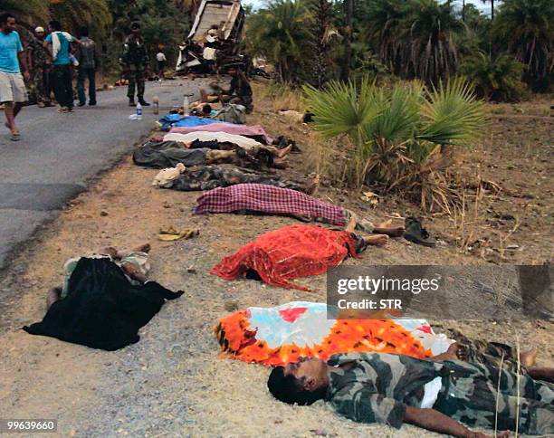 Bodies are seen by a roadside near the mangled wreckage of a bus which hit a landmine in Dantewada district on May 17, 2010. Maoist rebels blew up a...