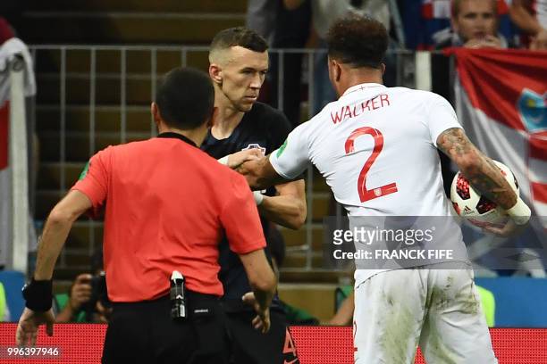 Turkish referee Cuneyt Cakir steps in between Croatia's forward Ivan Perisic and England's defender Kyle Walker during the Russia 2018 World Cup...